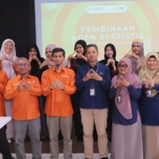 Foto bersama narasumber dari BPS, dosen FAST UAD, dan mahasiswa peserta Pembinaan Agen Statistik Tahap V di Universitas Ahmad Dahlan Yogyakarta. Peserta berpose dengan simbol tangan segitiga di depan layar proyektor.